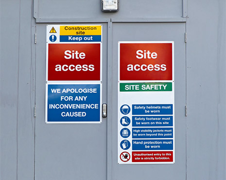 Image of a selection of safety signs hung on a door